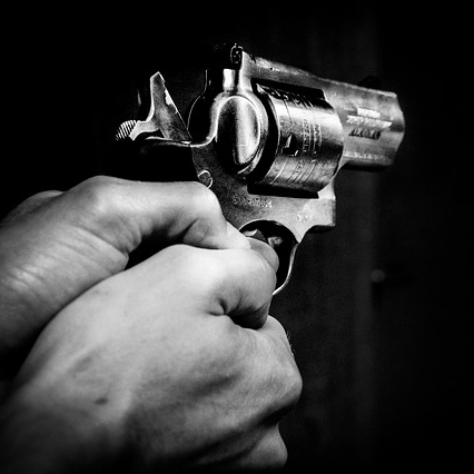 photo en noir et blanc de mains tenant un revolver