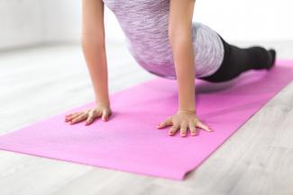 Buste femme en position de yoga sur un tapis