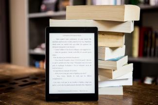 Liseuse devant une pile de livres